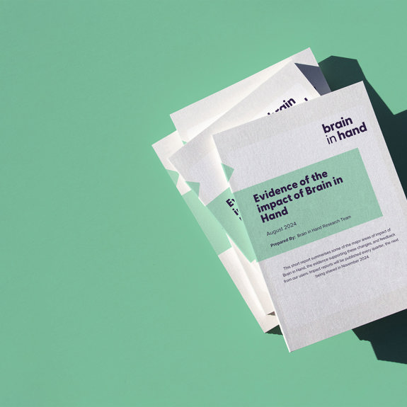 Graphic of a set of books and papers with the cover title reading "Evidence of the impact of Brain in Hand" on a green background.