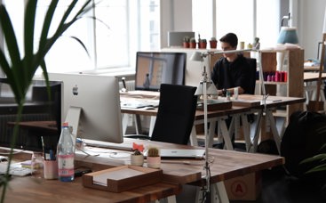 Office with one man sitting on desk