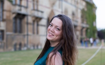 Woman smiling in front of university